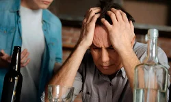 мужчина за столом обхватил голову руками